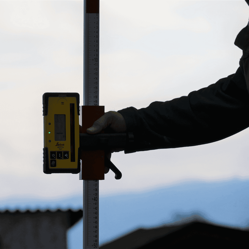 Leica Rod Eye 160 Laser Receiver on grade rod at construction site